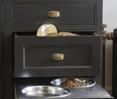 a black dresser with two bowls and one bowl on the bottom drawer that has food in it