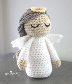 a crocheted angel doll sitting on top of a table