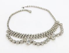 "~ 1950s lovely rhinestone scalloped evening necklace ~ Handset rhinestones ~ Beautiful silver metal backing ~ Adjustable fit ~ Excellent: Has more sparkle than photo shows! Length- 16\" (40.64 cm) Scallop drop- 1\" (2.54 cm) More Incredible Jewelry: glennasvintageshop.etsy.com Additional Vintage in our sister shop Glenna's Jewels: glennasjewels.etsy.com Instagram @glennas_clothing Facebook https://www.facebook.com/glennasclothing" Evening Necklace, Brass Pendant Necklace, Rhinestone Choker, Pendent Necklace, Choker Necklaces, Brass Pendant, Rhinestone Necklace, Vintage Rhinestone, Glass Necklace