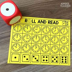 a roll and read game with a red dice next to it on top of a wooden table