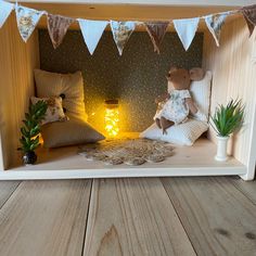 a stuffed animal sitting on top of a wooden shelf next to pillows and lights in a room