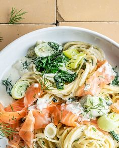 a white bowl filled with pasta and vegetables