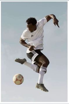 a man in the air with a soccer ball near his feet and one foot up