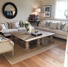 a living room filled with furniture and a mirror on the wall above it's coffee table