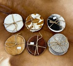 four round coasters tied up with twine on top of a cowhide surface