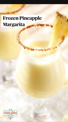 two glasses filled with white liquid and topped with a pineapple garnished in cinnamon