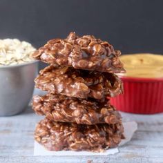 three cookies stacked on top of each other next to a bowl of oatmeal