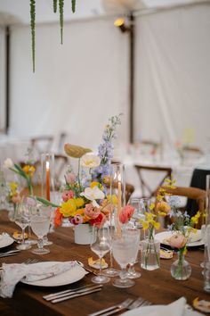 the table is set with flowers, candles and place settings for an elegant wedding reception