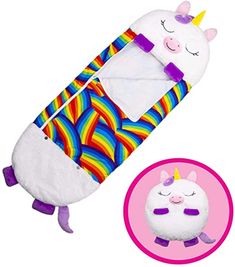 a stuffed unicorn sleeping bag next to a toy