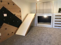 a room with stairs and a slide in the middle, next to a wall that has been built into it