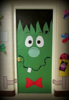 a door decorated with a green monster face and red bow tie