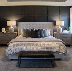 a large bed sitting next to two lamps on either side of the headboard and foot board