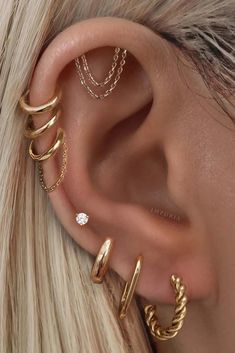 a woman's ear with three different types of piercings