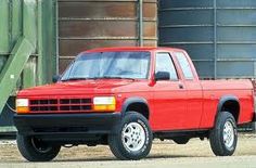 a red pick up truck parked in front of some silos