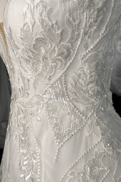 the back of a wedding dress with beading on it