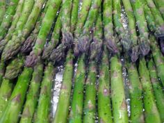 asparagus are being cooked on the grill