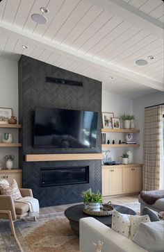 a living room filled with furniture and a flat screen tv mounted on the wall above a fireplace