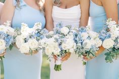 the bridesmaids are holding their bouquets with blue and white flowers