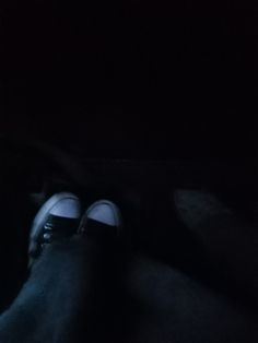 someone's feet in the dark with their shoes on