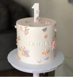 a white cake with flowers and the number one on it