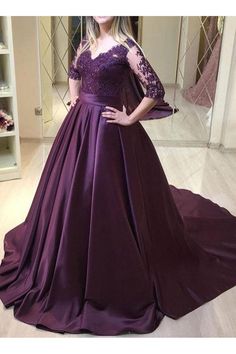 a woman standing in front of a mirror wearing a purple dress with sleeves and lace