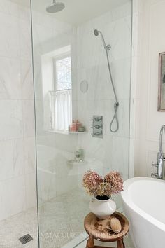 a white bath tub sitting next to a walk in shower with a glass enclosed shower door