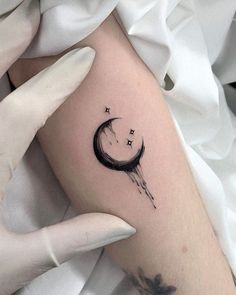 a woman's arm with a crescent and stars tattoo on it