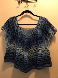 a crocheted top hanging on a hanger