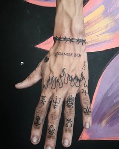 a person's hand with tattoos on it and the words strange boy written in black ink