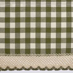 a green and white checkered table cloth with crochet lace trim on the edge