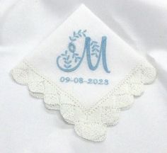 the monogrammed handkerchief is embroidered on top of a white shirt with blue trim