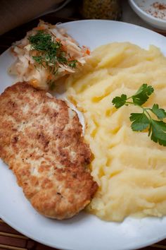 a white plate topped with mashed potatoes and meat