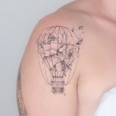 a man with a tattoo on his shoulder has a hot air balloon