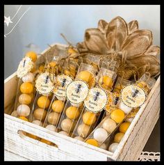 a wooden box filled with lots of yellow and white lollipops next to a string of twine