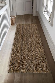 an area rug is on the floor in front of a white door and wooden floors