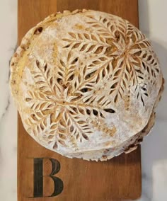 a wooden cutting board topped with a large piece of bread