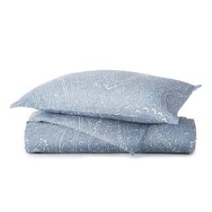 two pillows on top of each other with blue paisley print and white trimmings