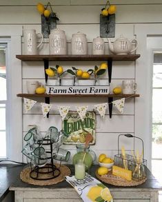 a kitchen counter with lemons and cups on the shelves above it is an old sign that says farm sweet farm