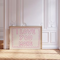 a sign that says i love you more on it in front of a white wall