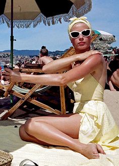 a woman in a yellow dress sitting on the beach