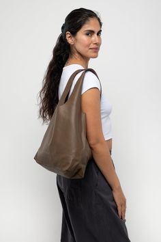 We’ve sewn our shopping bag in matte colors for those who prefer a clean, minimalist style. Throw in your daily essentials and elevate any look with a touch of casual elegance. Due to the high quality of the leather, this bag is extremely durable and will age beautifully with appropriate care. This artisanal product is made of genuine leather. All scars are characteristics of the skin and not imperfections. We hope you enjoy this unique handmade object. | Monochromatic Leather Shopping Bag for W Modern Hobo Bag With Smooth Grain For Everyday Use, Versatile Shoulder Bag With Smooth Grain For Everyday Use, Modern Smooth Grain Shoulder Bag For Shopping, Versatile Smooth Grain Shoulder Bag, Versatile Bucket Bag With Smooth Grain For Everyday Use, Modern Everyday Bag With Smooth Grain, Versatile Hobo Bag With Smooth Grain For Everyday Use, Versatile Hobo Bag For Everyday Use With Smooth Grain, Versatile Tote Shoulder Bag With Smooth Grain