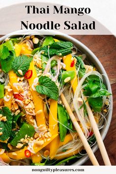 thai noodle salad in a white bowl with chopsticks on the side and text overlay that reads, thai mango noodle salad