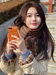 a young woman is holding up her cell phone to take a selfie in front of some stairs