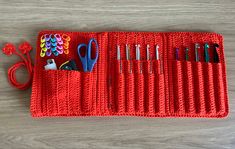 a red crocheted case with scissors and other crafting supplies