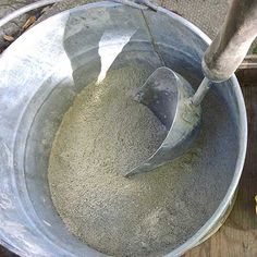 a metal bucket filled with cement next to a banana peel