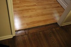 an empty kitchen with hard wood floors and white appliances