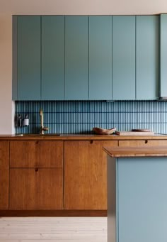 a kitchen with blue cabinets and wooden counter tops