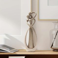 a vase sitting on top of a wooden table next to a framed photo and other items