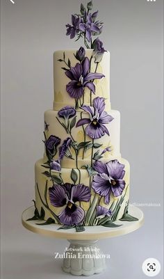 a three tiered cake with purple flowers on it