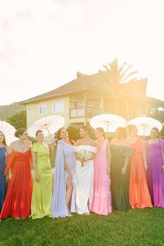 a group of women standing next to each other on top of a lush green field